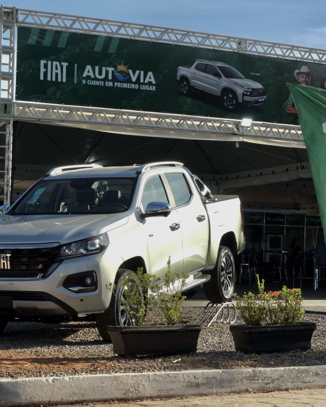 Picape Fiat prata exposta sob a fachada em treliça do stand Autovia na Agrotins 2026 em Palmas-TO