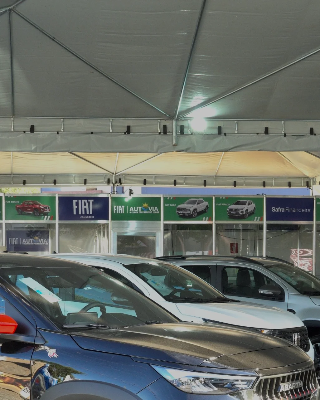Carros Fiat sob tenda com estandes ao fundo no stand Autovia na Agrotins 2026 em Palmas-TO