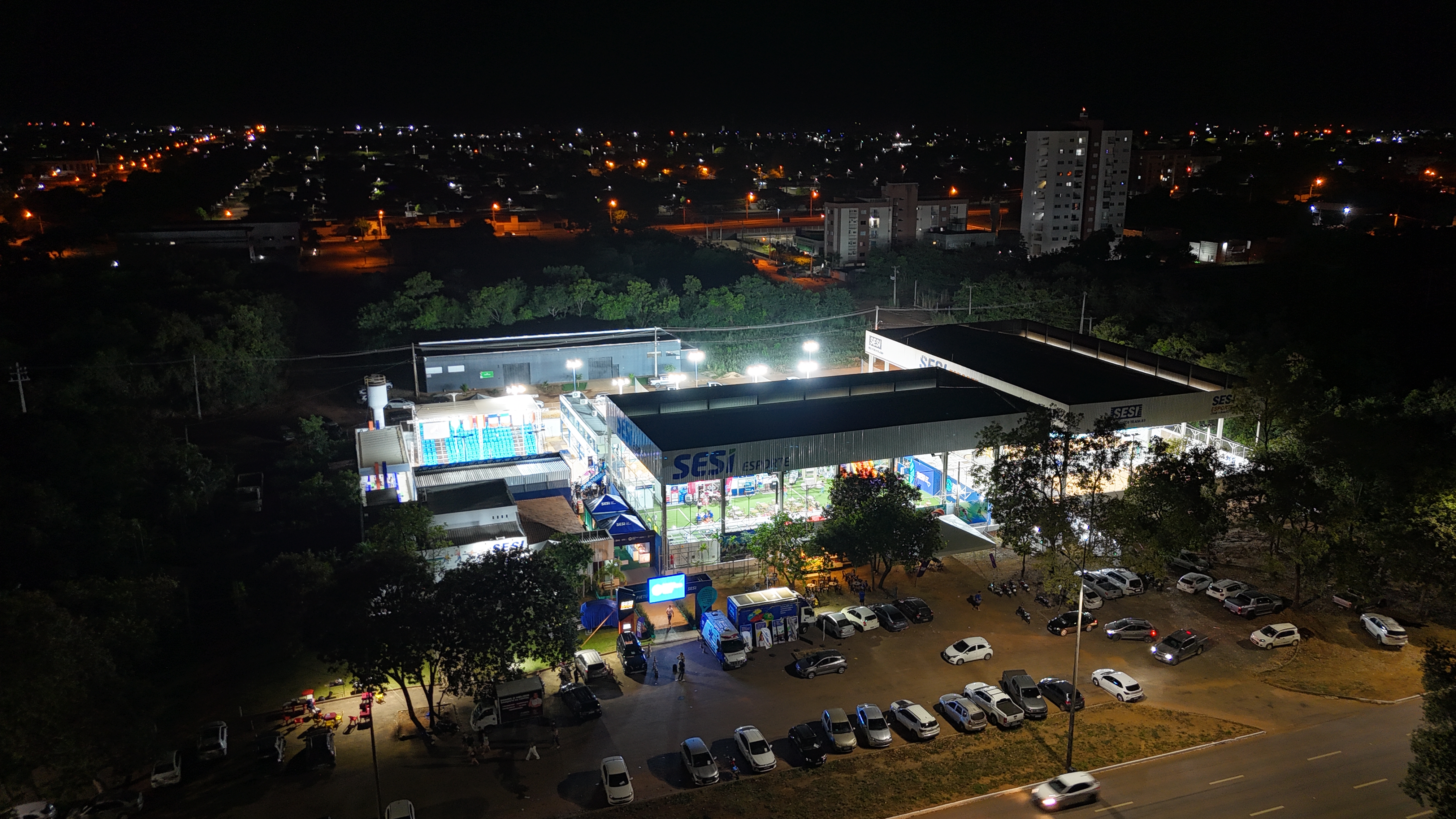 Vista aérea noturna da arena iluminada do Sesi BT 400 em Palmas-TO