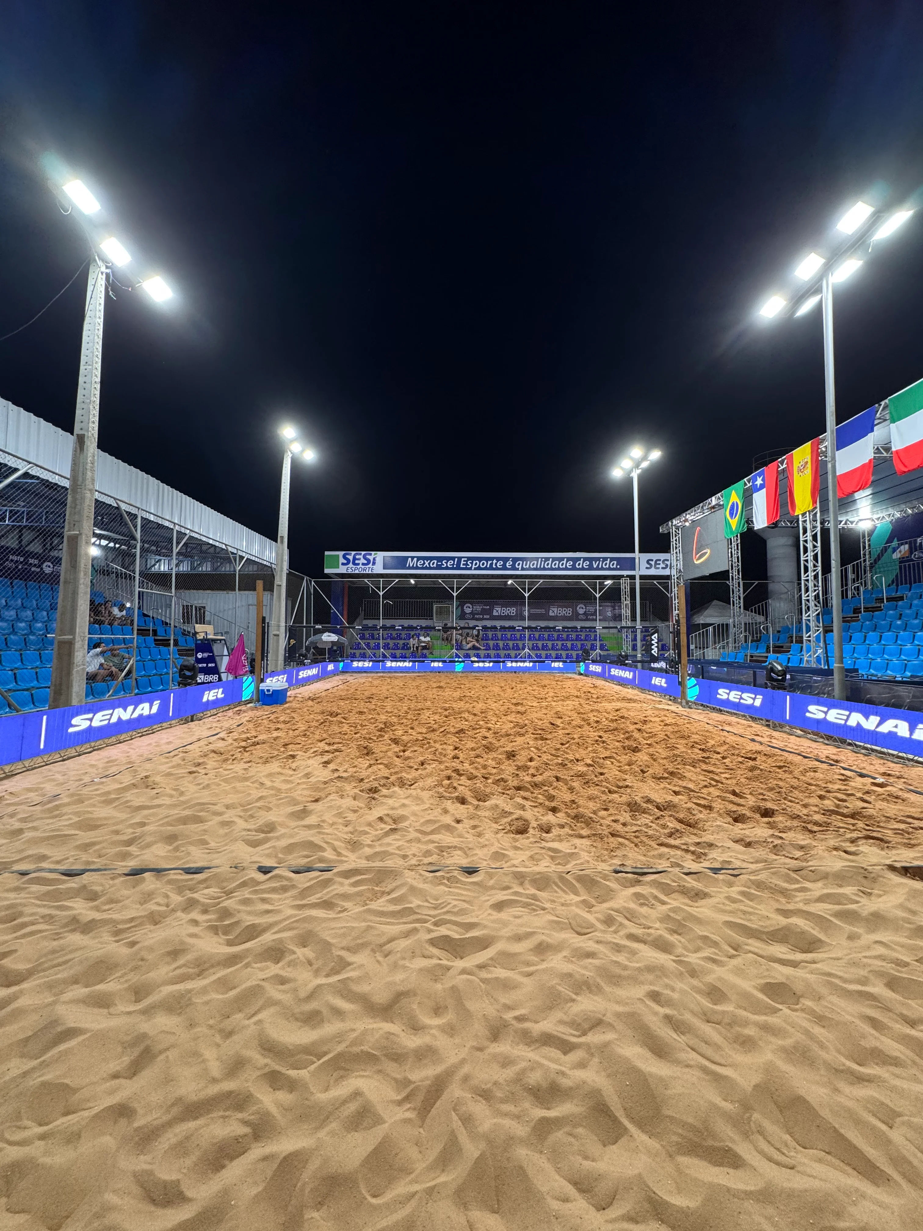 Quadra central de areia com arquibancadas e iluminação noturna no Sesi BT 400 em Palmas-TO