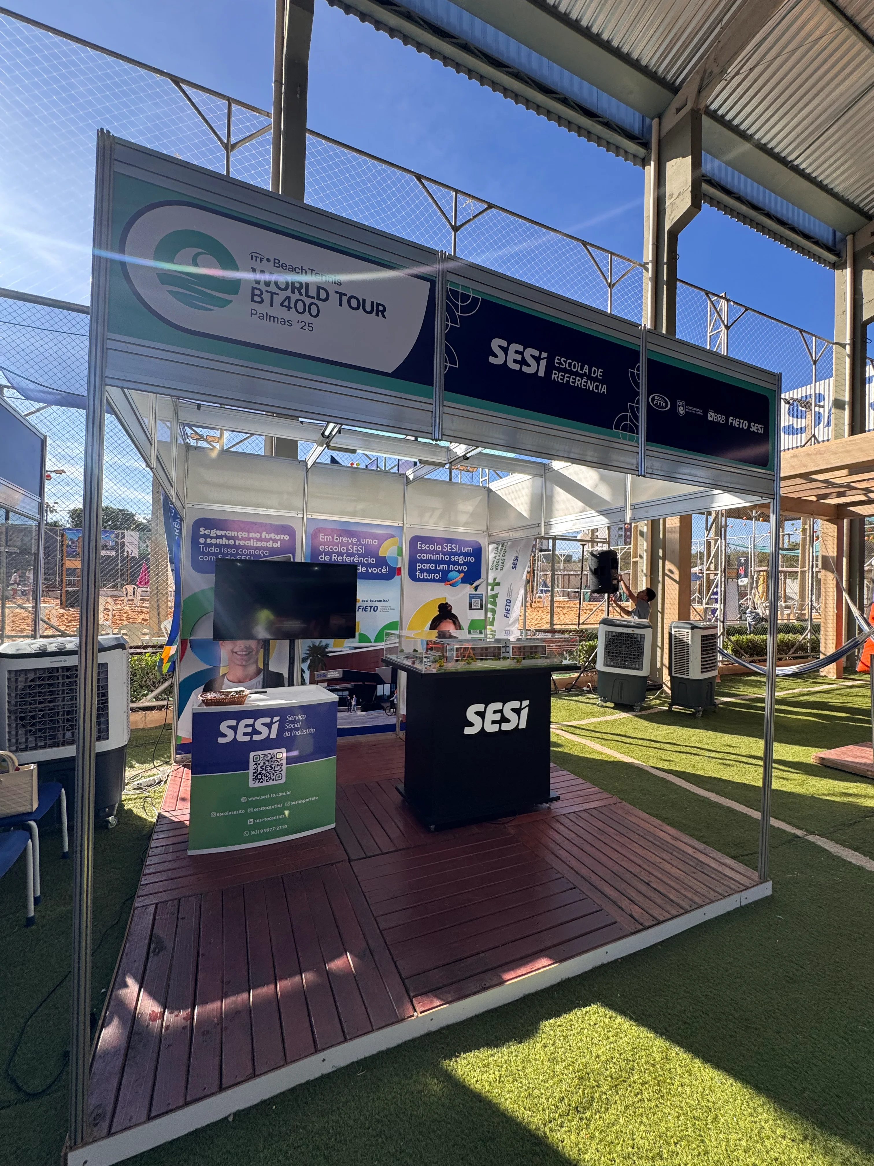 Stand do Sesi com piso de madeira e treliça sobre grama sintética no Sesi BT 400 em Palmas-TO